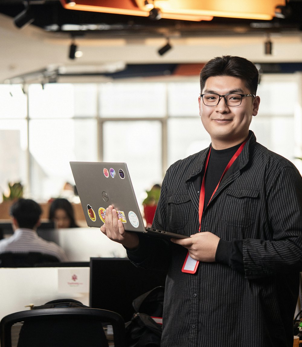 A Nexusity engineer holding a laptop in an open-plan office