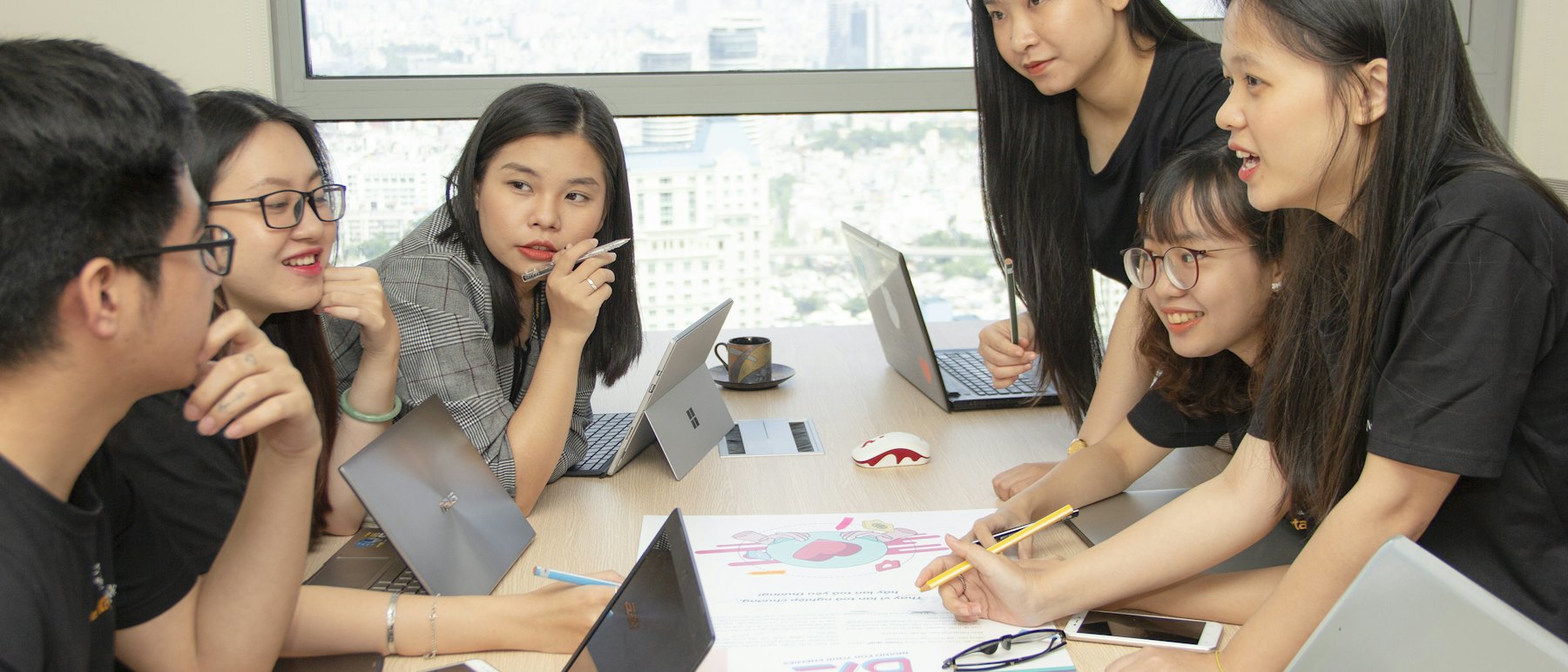 Nexusity engineers planning a client rollout around a shared table with laptops